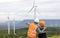 Progressive engineer with his son in the wind farm atop of the mountain.