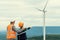 Progressive engineer with his son in the wind farm atop of the mountain.