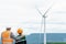 Progressive engineer with his son in the wind farm atop of the mountain.