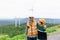 Progressive engineer with his son in the wind farm atop of the mountain.