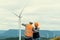 Progressive engineer with his son in the wind farm atop of the mountain.