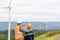 Progressive engineer with his son in the wind farm atop of the mountain.