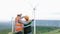 Progressive engineer with his son in the wind farm atop of the mountain.