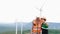 Progressive engineer with his son in the wind farm atop of the mountain.