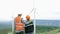 Progressive engineer with his son in the wind farm atop of the mountain.