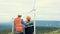 Progressive engineer with his son in the wind farm atop of the mountain.