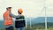 Progressive engineer with his son in the wind farm atop of the mountain.