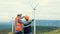 Progressive engineer with his son in the wind farm atop of the mountain.