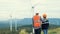 Progressive engineer with his son in the wind farm atop of the mountain.