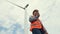 Progressive engineer working with the wind turbine, with the sky as background.