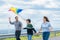 Progressive happy carefree family vacation concept flying kite with wind turbine