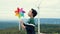 Progressive young asian boy playing with wind turbine toy at wind turbine farm.