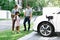 Progressive young happy family living in a home with an electric car.