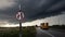 Prohibited overtaking traffic sign on a countryside road with stormy cloud