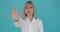 Prohibiting Woman Showing Stop Gesture with Palm on Blue Background