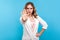 Prohibition concept. Portrait of serious woman doing stop gesture, warning sign with raised palm. blue background