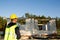 Project architect stands near construction site of a house with the walls are made of a porous concrete block and a brick.