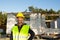 Project architect stands near construction site of a house with the walls are made of a porous concrete block and a brick.