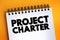 Project charter - statement of the scope, objectives, and participants in a project, text concept on notepad