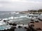 The promenade and lido at puerto de la cruz in tenerife with people on the seafront and dramatic waves breaking over the rocks