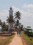 The promenade and the lighthouse, green palm trees and tourists