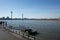 Promenade riverside and bridge toward pier, pontoon or buoy over Rhine River suspension bridge and Rhine tower in DÃ¼sseldorf.