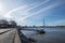 Promenade riverside and bridge toward pier, pontoon or buoy over Rhine River suspension bridge and Rhine tower in DÃ¼sseldorf.