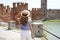 Promenade riverside in Verona, Italy. Back view of lady walking along promenade with medieval fortress Castelvecchio castle and