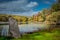 Prominent boulder displayed under dramatic crisp autumn sky over Tyrrel Lake at Innisfree Garden, Millbrook, New York