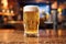 A promotional shot with a full glass of light camp beer with droplets on the sides in the bar.