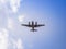 A propeller airplane sillhouette as it flies overhead.