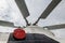 The propeller of the helicopter close-up against a gray sky.