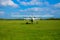 A propeller light aircraft at a grass airfield