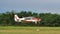 Propeller plane lands on a grassy runway after towing a glider in flight