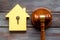 Property auction concept. Judge gavel near house on dark wooden background top-down