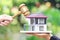 Property auction, Woman hand holding gavel wooden and model house on natural green background, lawyer of home real estate and