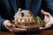 Property safeguarded Businessman protects wooden home model with his hand