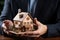 Property safeguarded Businessman protects wooden home model with his hand