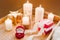 Proposal, engagement concept. Red box with gold engagement ring and gift box on background of burning candles. Romantic dinner.