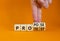 Propose instead protest symbol. Businessman turns wooden cubes, changes the word `protest` to `propose`. Beautiful orange tabl