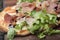 Prosciutto, arugula and cheese flatbread dish baked until crispy