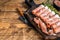 Prosciutto crudo Dry cured parma ham on a wooden cutting board with thyme. wooden background. Top View. Copy space