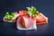 Prosciutto. Curled Slices of Delicious Prosciutto with parsley leaves on granite board. Prosciuto with spice cherry tomatoes