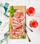 Prosciutto di Parma ham slices and rose wine glasses