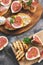 Prosciutto with figs . Fresh figs with ham and cheese on a grilled toast, rustic background. Appetizing snack. Top view,toned