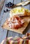 Prosciutto ham and bread on a wooden background. Italian cuisine. Rustic style