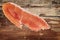 Prosciutto Slice on Old Wooden Background