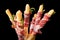 Prosciutto wrapped around grissini breadsticks. Black background