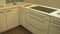 Prospective view of the kitchen base cabinets, kitchen doors and drawers are made of the flat wood panels in white color. As a kit