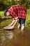 Prospector panning with aluminum pan gold in creek